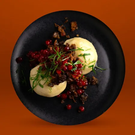 Kroppkakor med rimmat sidfläsk serveras med skirat smör och rårörda lingon